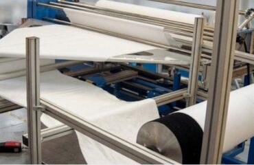 Automated tubular knit fabric slitting machine cutting fabric